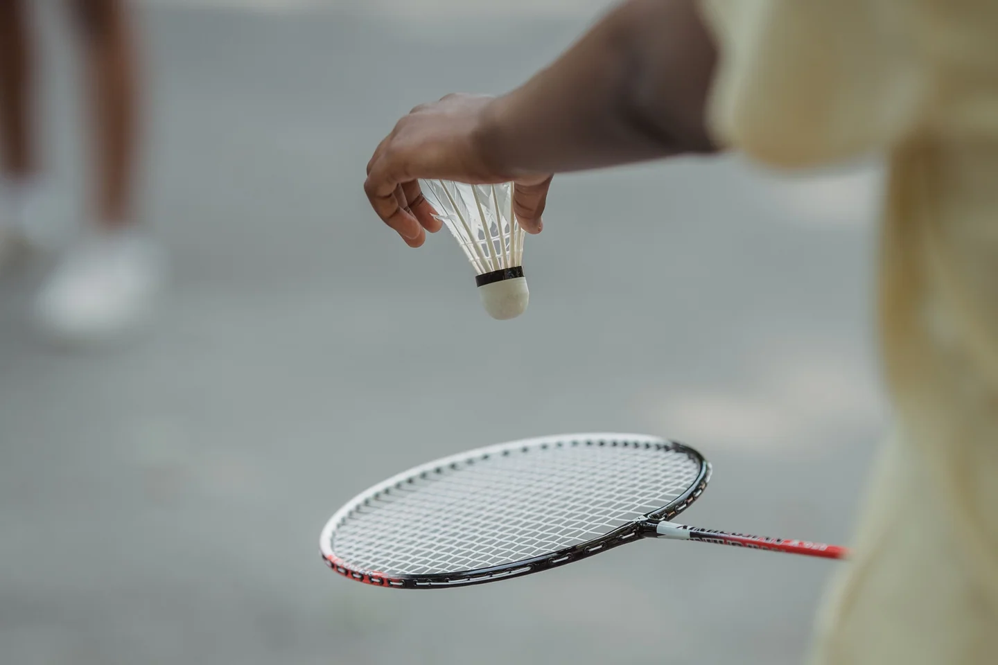 Servis öncesinde badminton raketinin üzerinde tüytop tutan oyuncu