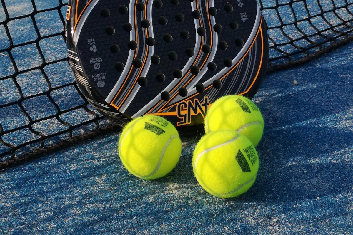 Filenin yanında padel raketi ve toplar