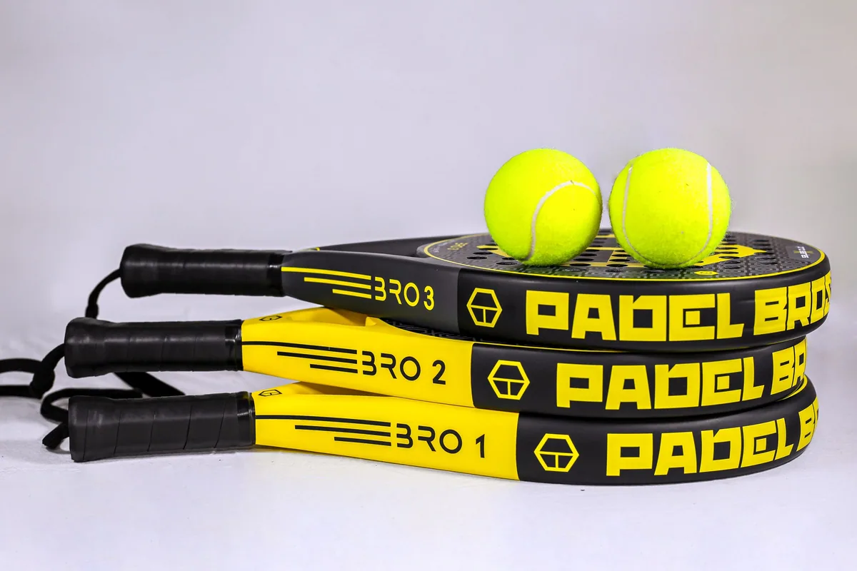 Palas de pádel apiladas y pelotas amarillas