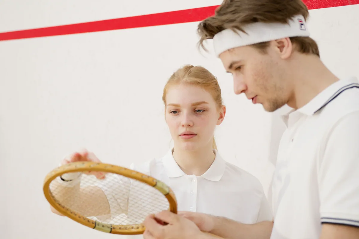 Bir raketin kordajını inceleyen iki squash oyuncusu