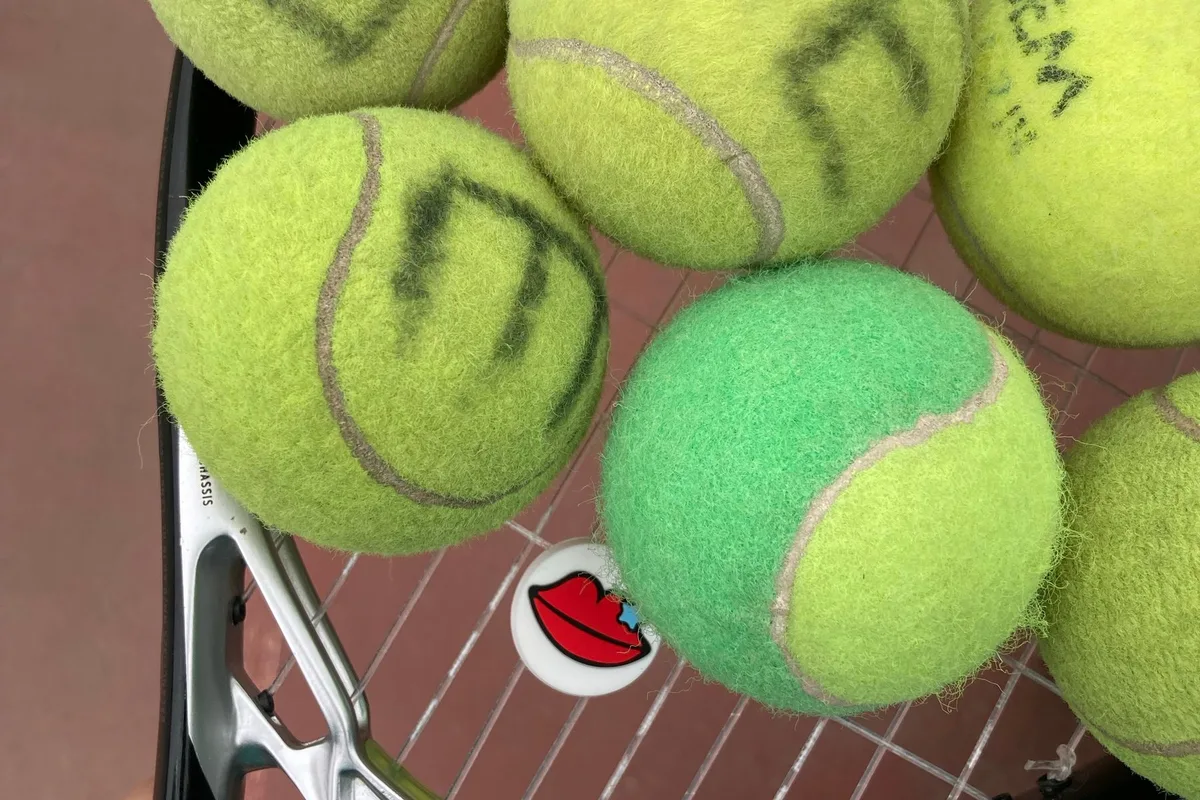 Raket kordajının üzerinde duran tenis topları