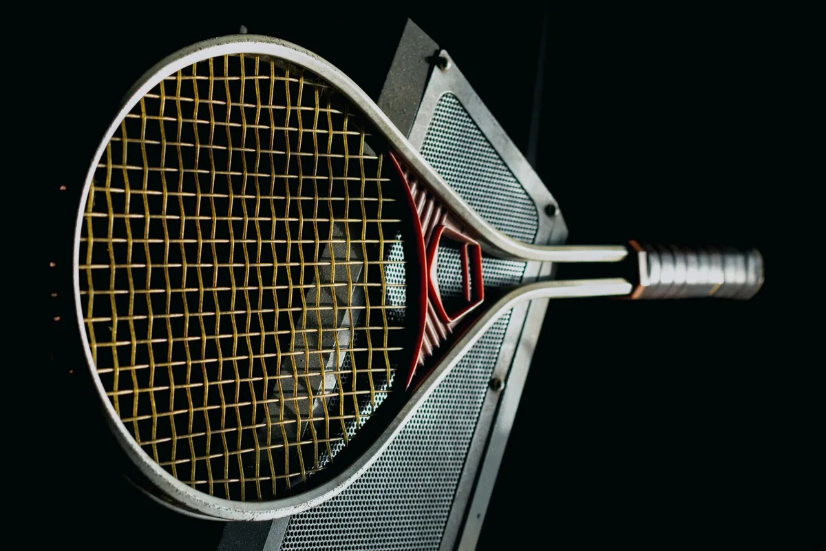 Koyu fonda tenis raketinin kafası ve kordajı