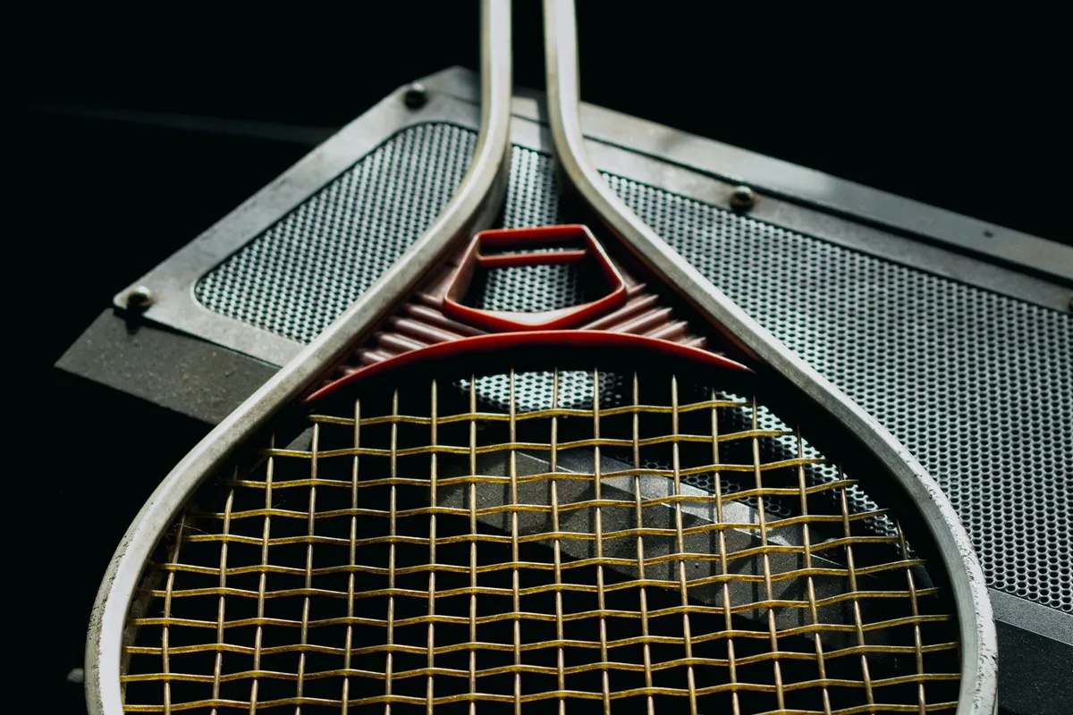 Metal bank üzerindeki tenis raketinin kordajına yakın bakış